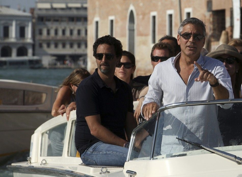 U.S. actor Clooney gestures as he arrives by speedboat in Venice
