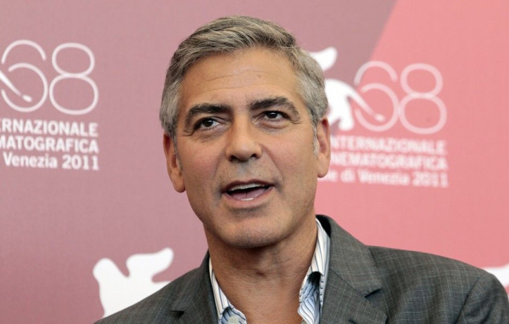 Clooney reacts as he poses during a photocall of his film &quot;The Ides of March&quot; at the 68th Venice Film Festival