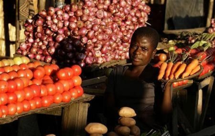 A girl poses for a photographer at her vegetable stall in Tsangano, central Malawi