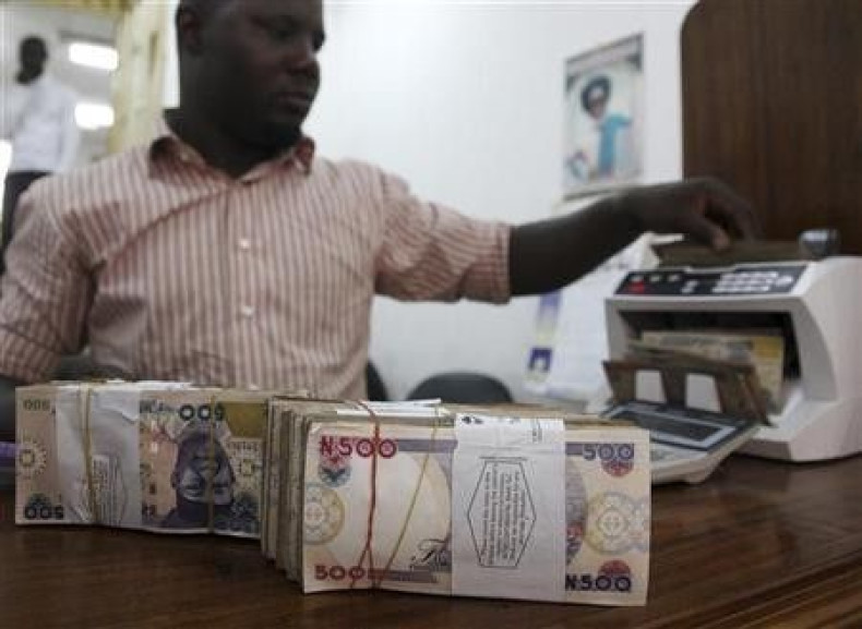 A money dealer counts the Nigerian naira on a machine in his office in the commercial capital of Lagos