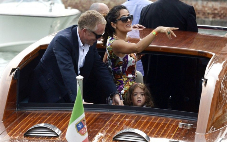 Actress Salma Hayek (C), her husband Francois-Henri Pinault and their daughter Valentina arrive by speedboat to the 68th Venice Film Festival
