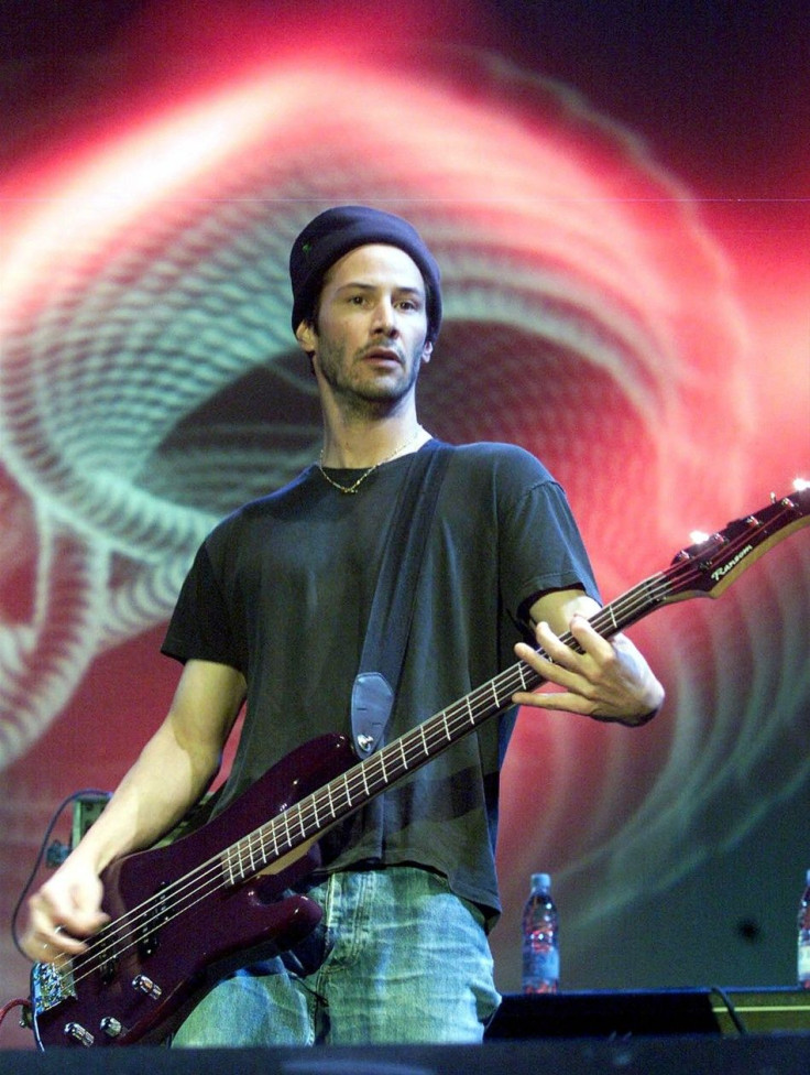 Hollywood actor Keanu Reeves plays the bass guitar during a concert performance by his band "Dogstar" at Huamark Staduim in Bangkok, Thailand