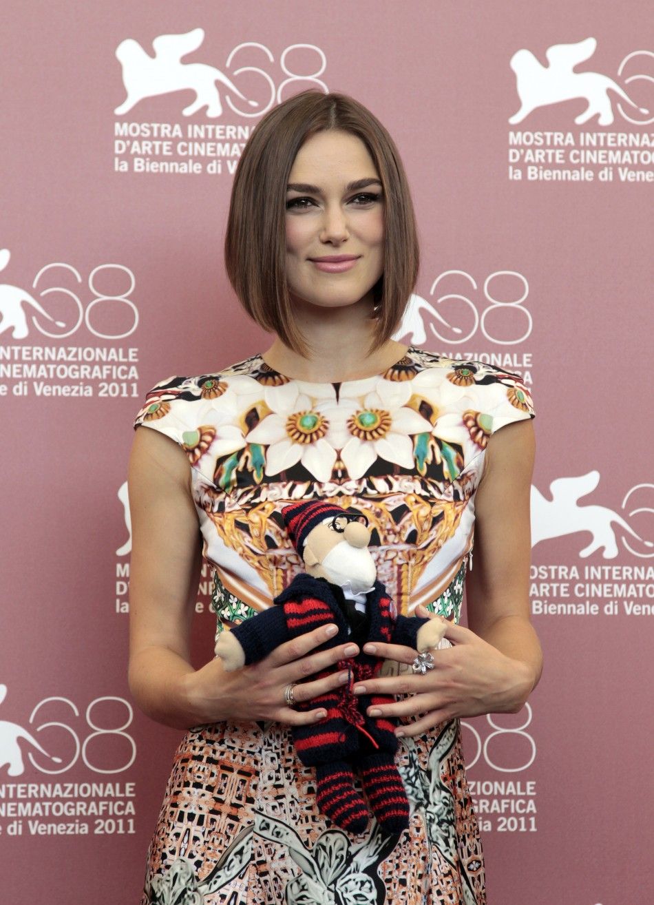 Actress Knightley holds toy given to her by co-star Mortensen at a photocall for their film quotA Dangerous Methodquot which is in competition at the 68th Venice Film Festival