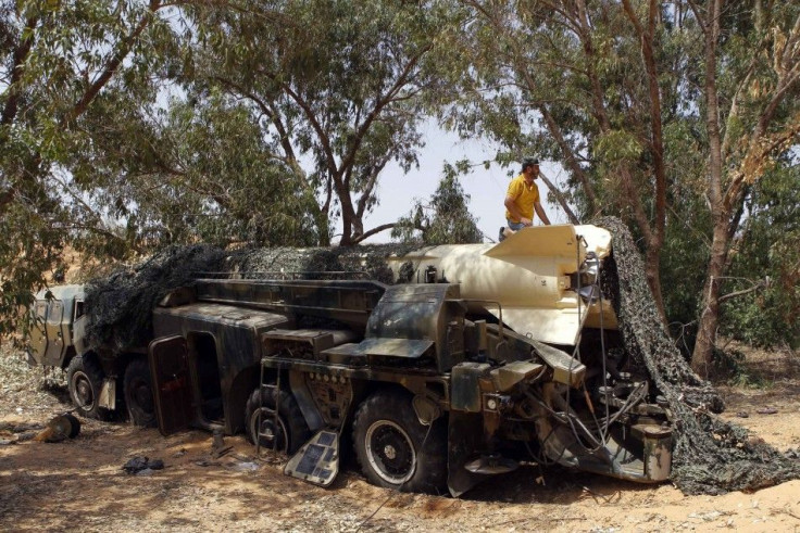 A rebel fighter stands on a Russian-made scud missile that was found in Junine