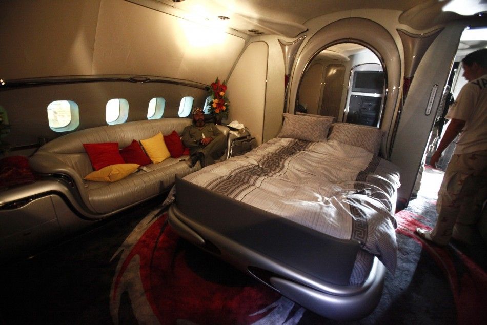 A Libyan rebel fighter sits in a bedroom of Muammar Gadhafis private plane, at the international airport in Tripoli August 28, 2011. 