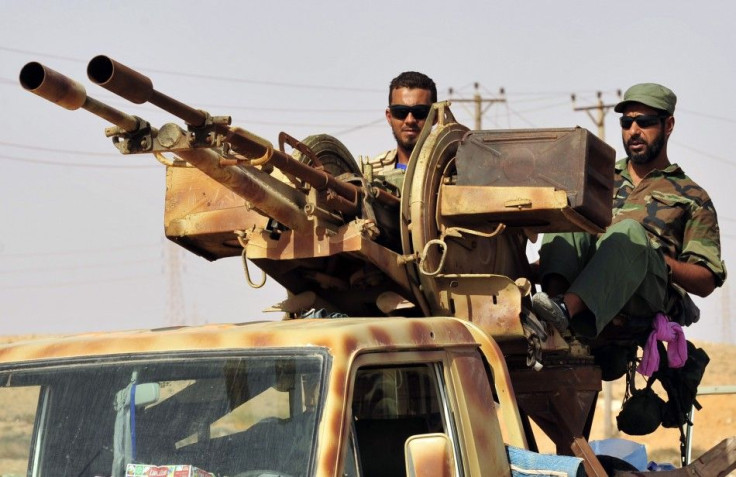 Anti-Gaddafi fighters stand guard as they gather in Al-Noflea to prepare for a sweep of the area for pro-Gaddafi forces