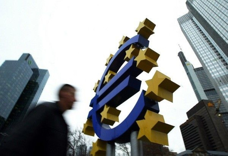 A pedestrian walks by a huge Euro logo in front of the European Central Bank (ECB) in Frankfurt 