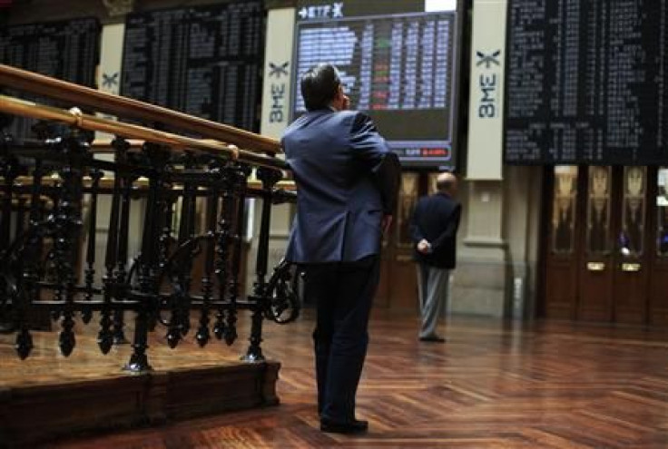 Traders look at screens at the Madrid bourse
