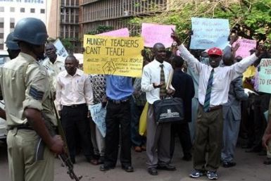 Ugandan primary school teachers hold banners and shout slogans during a demonstration in Kampala