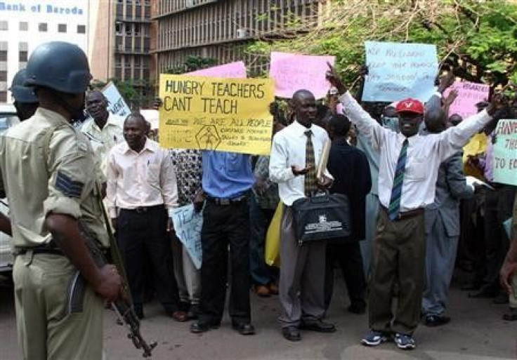 Ugandan primary school teachers hold banners and shout slogans during a demonstration in Kampala