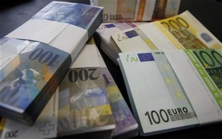 Stacks of Swiss franc and Euro banknotes are displayed in a bank in Bern