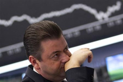 Trader reacts at his desk in front of the DAX board at the Frankfurt stock exchange