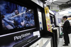 A man plays a game on Sony Corp&#039;s PlayStation 3 game console at an electronic store in Tokyo