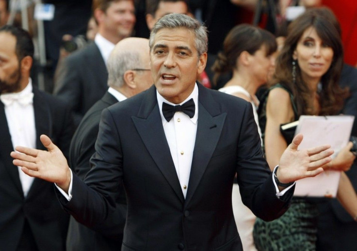 U.S. actor Clooney gestures as he arrives on &quot;The Ides of March&quot; red carpet at the 68th Venice Film Festival