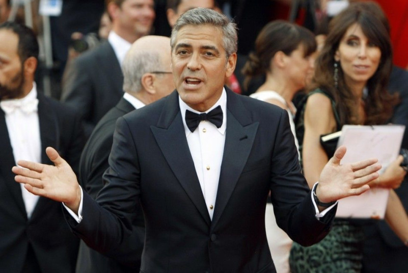 U.S. actor Clooney gestures as he arrives on "The Ides of March" red carpet at the 68th Venice Film Festival