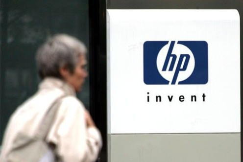 A woman walks past the Hewlett Packard logo