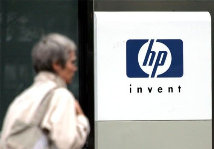 A woman walks past the Hewlett Packard logo