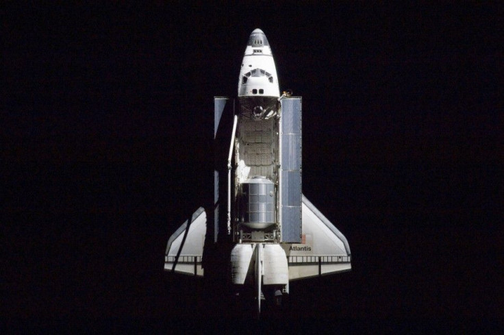 A 400 millimeter lens was used by an International space station crew member to capture this image of the space shuttle Atlantis.