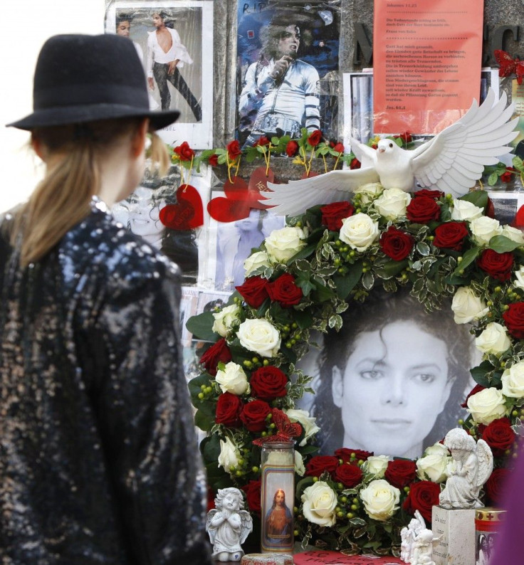 A woman observes a moment of silence at a memorial place for the late entertainer Michael Jackson in Munich