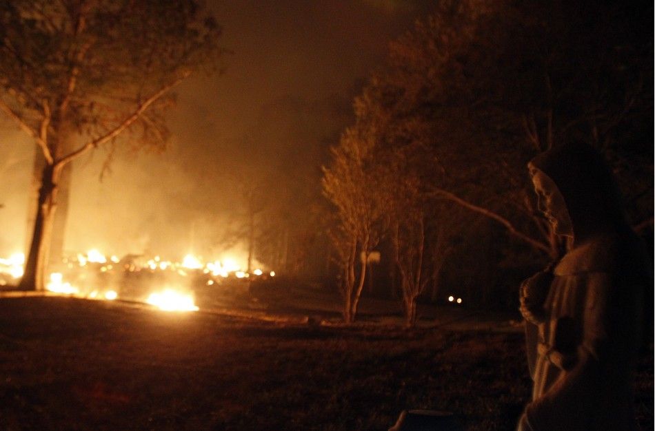 A religious figurine is illuminated by wildfires burning out of control near Bastrop, Texas September 5, 2011