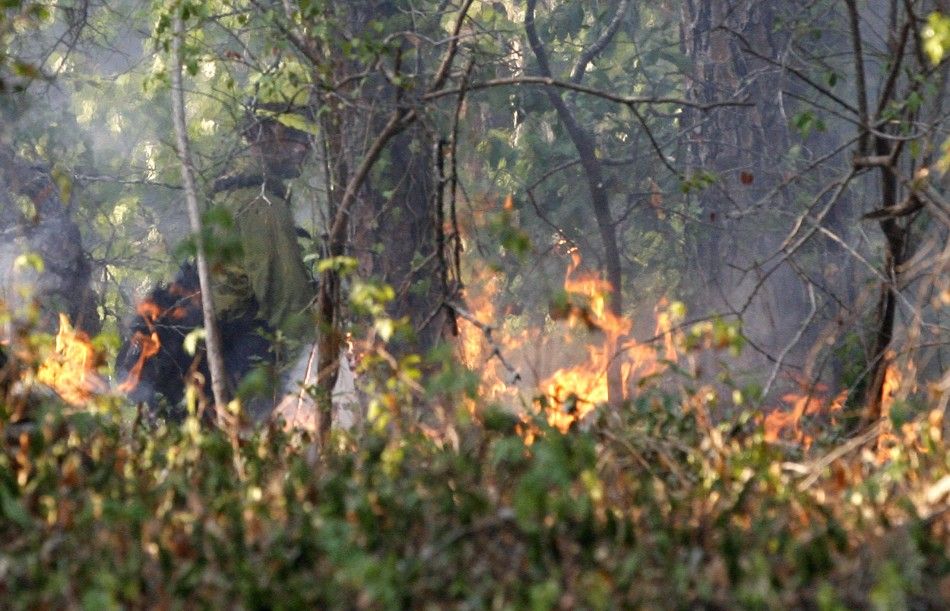 A U.S. forestry worker watches a controlled burn created to seal off a wildfires path as it approaches a house near Bastrop, Texas September 6, 2011.