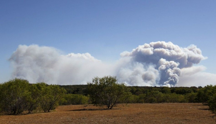 A cloud of smoke rises from a wildfire as it burns out of control near Bastrop, Texas, September 5, 2011.