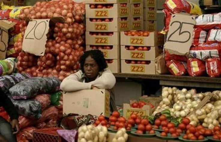 A vegetable vendor sits next to her stall in Kliptown, Soweto