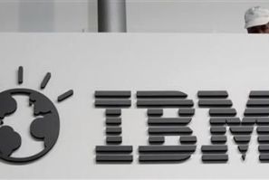 A worker is pictured behind a logo at the IBM stand on the CeBIT computer fair in Hanover