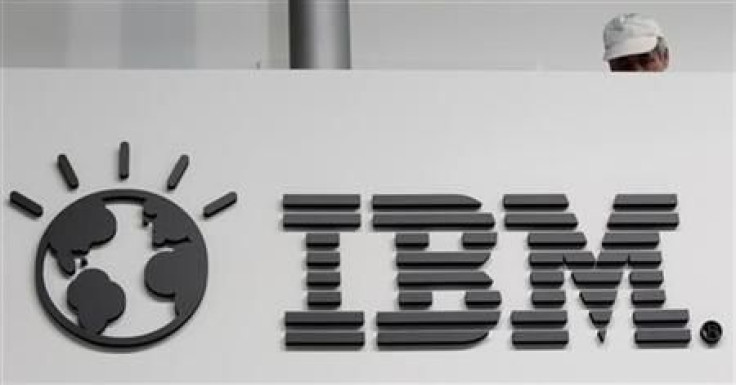 A worker is pictured behind a logo at the IBM stand on the CeBIT computer fair in Hanover