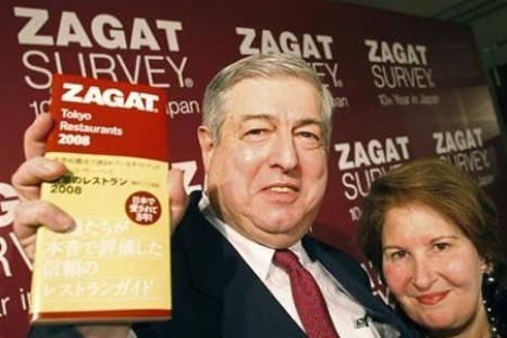 Zagat Survey co-founders Tim (L) and Nina Zagat pose with the latest version of their guide to Tokyo restaurants at a news conference in Tokyo