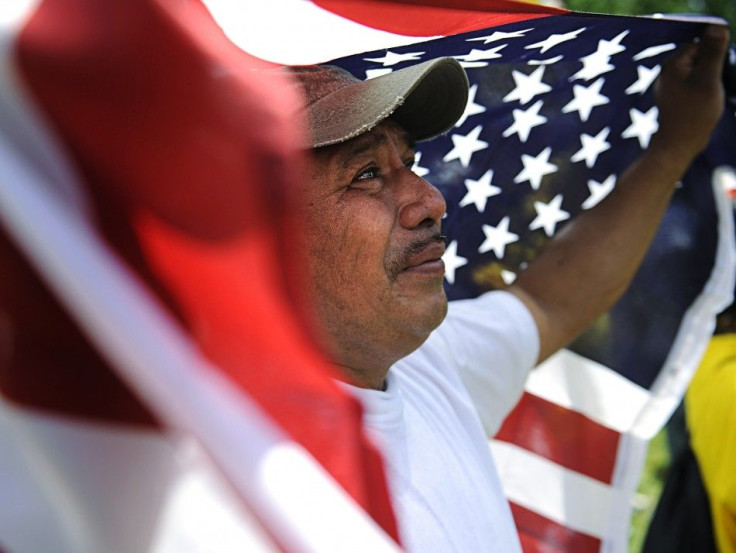 A man weeps and holds a U.S. flag at a May Day rally in Lafayette Square Park near the White House in Washington