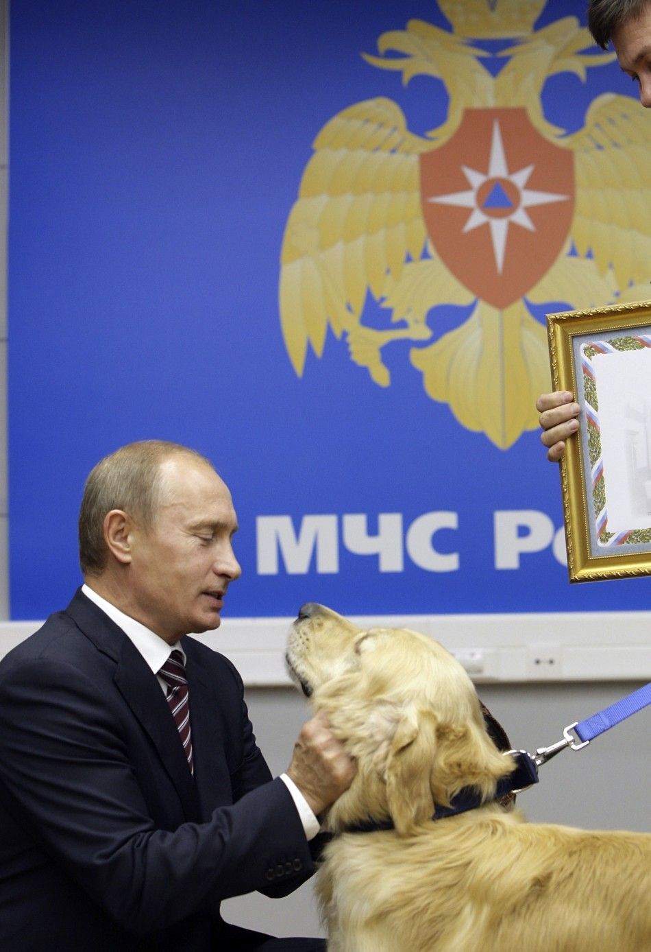 Russias Prime Minister Vladimir Putin strokes a rescue dog as he visits Emergency Situation Ministry in Moscow