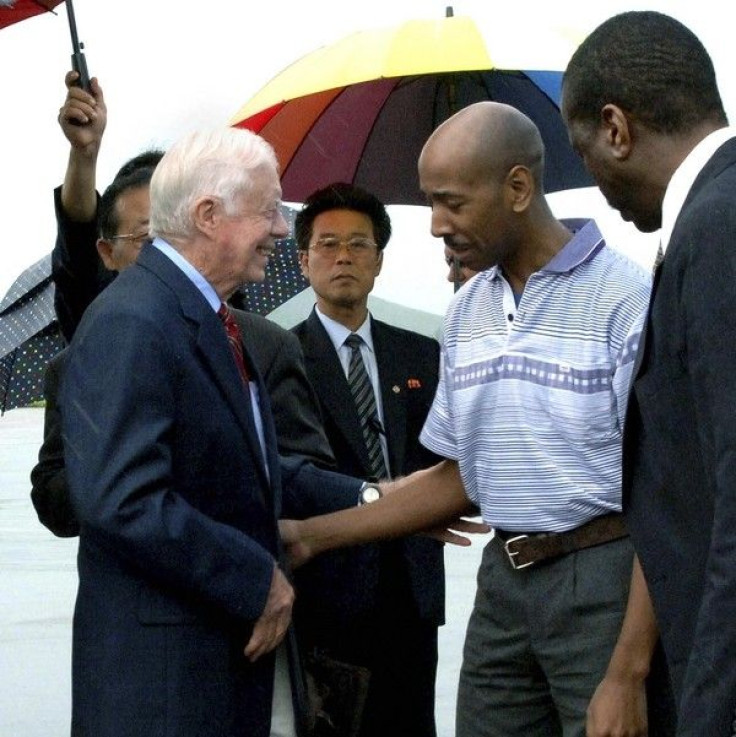 Former U.S. President Jimmy Carter (L) and Aijalon Mahli Gomes (2nd R) talk before they leave Sunan airport in Pyongyang August 27, 2010. 