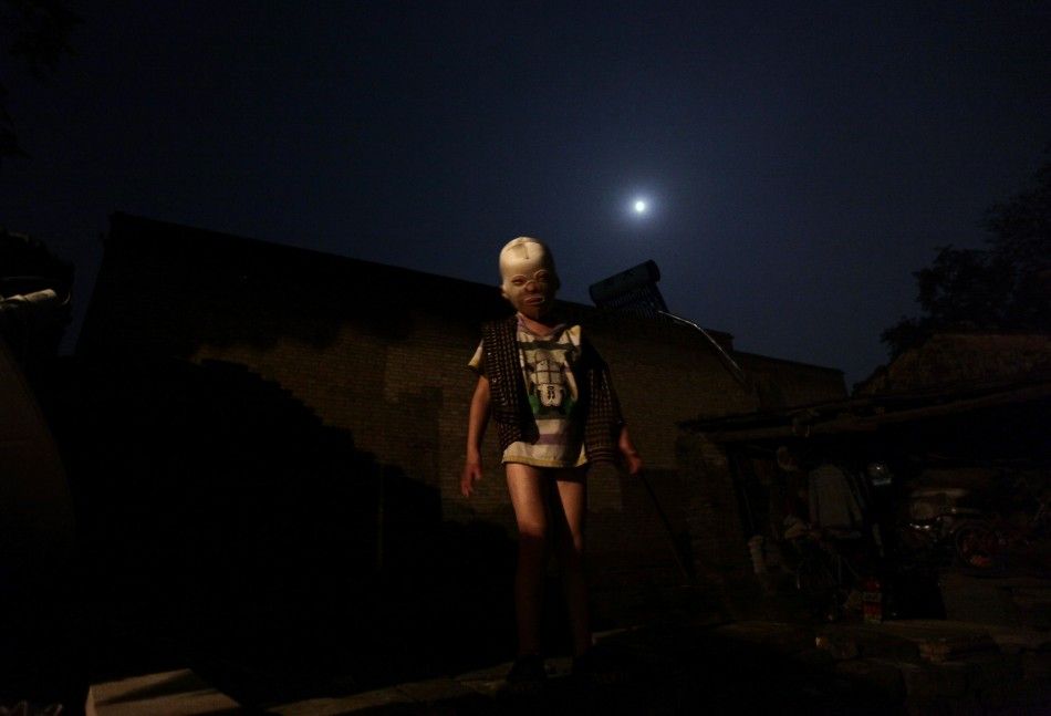 Wang Gengxiang, known as quotMasked Boyquot, plays in the front courtyard of his house at Mijiazhuang village
