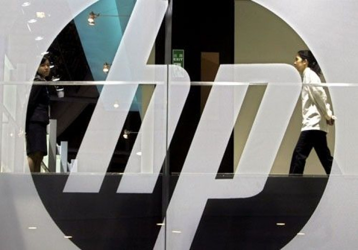 An employee walks past a Hewlett-Packard logo 