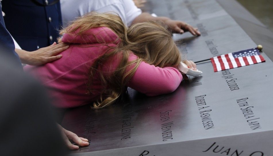 Mourners touch the names of lost loved ones during ceremonies marking the 10th anniversary of the 911 attacks on the World Trade Center, in New York
