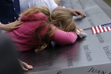 Mourners touch the names of lost loved ones during ceremonies marking the 10th anniversary of the 9/11 attacks on the World Trade Center, in New York