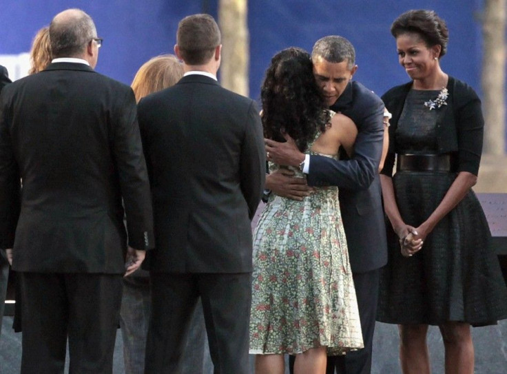U.S. President Barack Obama embraces victims&#039; family members as first lady Michelle Obama stands by at the 9/11 Memorial during the tenth anniversary ceremonies at the World Trade Center site in New York
