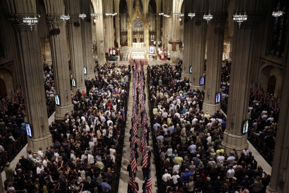 Firefighters leave St. Patricks Cathedral with U.S. flags during ceremony to honor New York firefighters that were killed in 911 attacks on World Trade Center, in New York