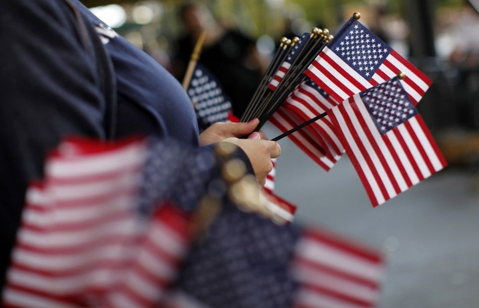 Women pass out U.S. Flags to passers-by during a ceremony marking the 10th anniversary of the 911 attacks on the World Trade Center in New York