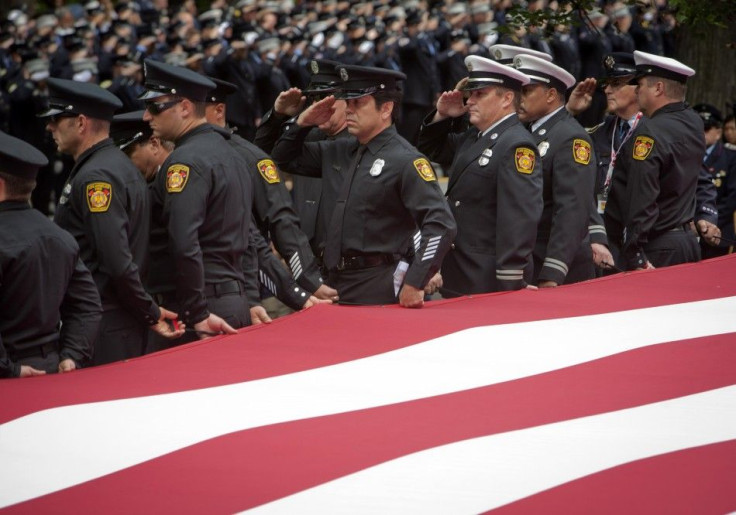 Los Angeles firemen salute as they hold a large American flag during a ceremony honoring firefighters and public servants killed in the 9/11 attacks on the World Trade Center, on the 10th anniversary, in New York