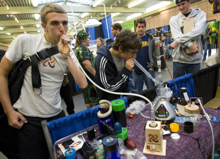 Young men smoke from a vapor pipe and water pipe at the The Wonders of Cannabis Festival in San Francisco