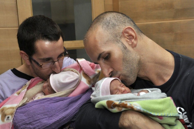 Mauro and his partner Juan Carlos kiss their twin babies at a private hospital in New Delhi