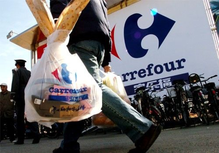 A Chinese man carries grocery bags after shopping at french hypermarkert Carrefour in Beijing, China