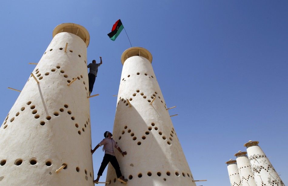 Anti-Gaddafi fighters climb in a pigeon farm in Gaddafi house compound in Assdada Fort