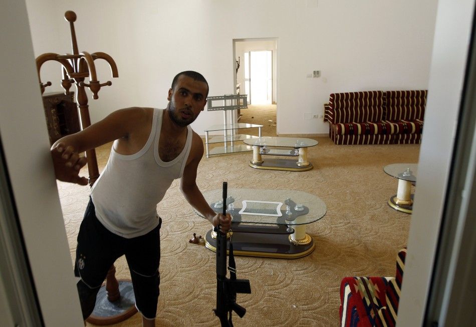An anti-Gaddafi fighter holds a rifle in Gaddafi house in Assdada Fort