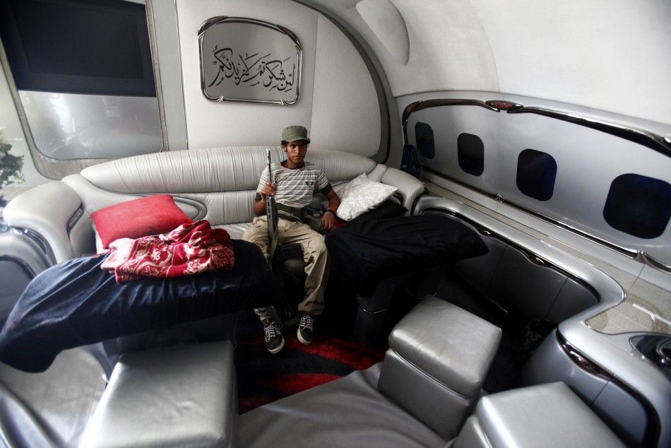 A Libyan rebel fighter sits in the sitting room of Moammar Gadhafis private plane at the international airport in Tripoli