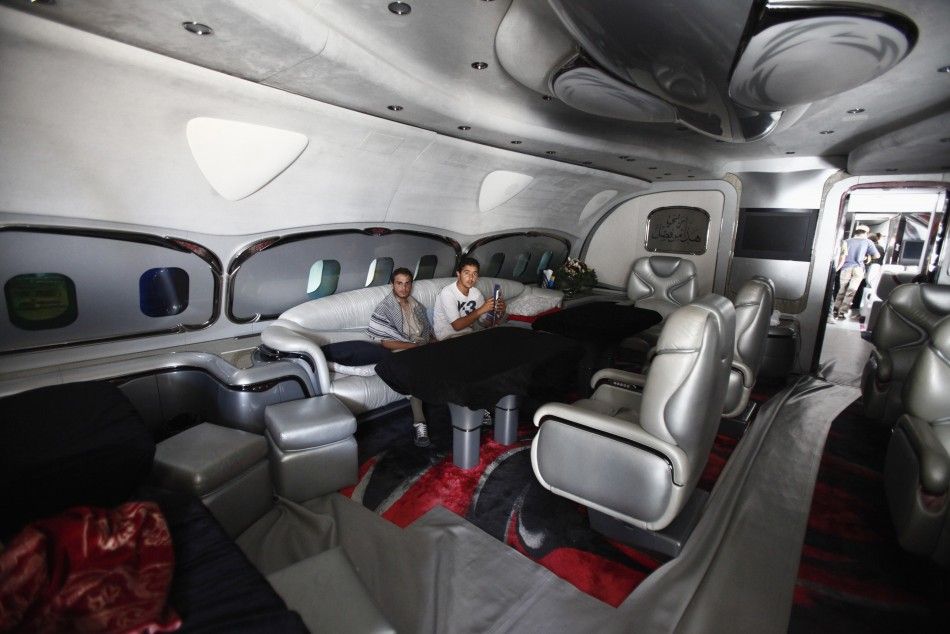 Libyan rebel fighters sit at the sitting room of Muammar Gaddafis private plane