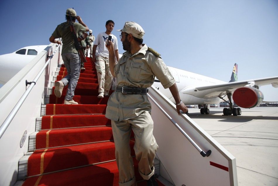 A Libyan rebel fighter takes a photo of Muammar Gaddafis private plane