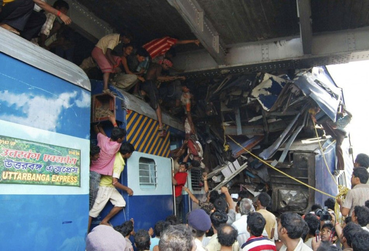 Volunteers conduct rescue operations on the wreckage of train carriages at Sainthia